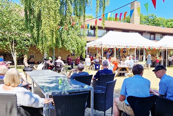 Foto fra festivalen med vimpler, scene, telte og publikum