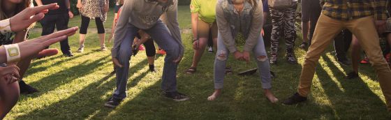 Foto, som viser et udsnit af unge mennesker i bevægelse på en solbeskinnet græsplæne